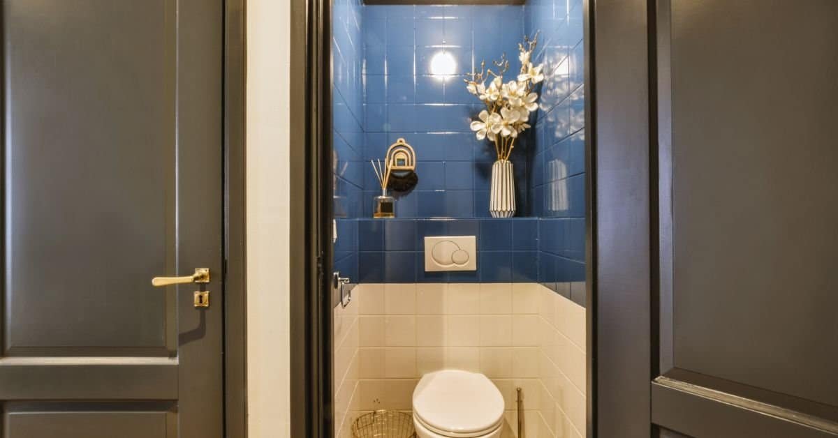 tiny half bathroom ideas -A bathroom with a toilet and blue tile